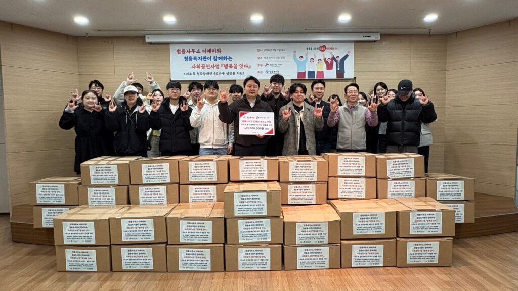 법률사무소 디에이 직원들이 청음복지관에서 생필품 포장 후 ‘사랑’ 수어를 표현하며 단체사진을 촬영한 모습