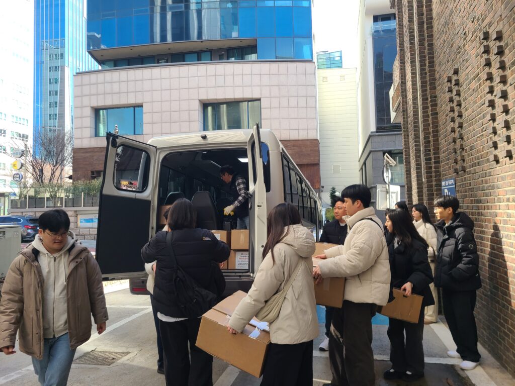 법률사무소 디에이 직원들이 자원봉사 후 포장된 행복박스를 차량으로 옮기는 모습